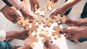 Diákok és fiatalok együtt rakják össze a kirakós darabokat, szimbolizálva a közösséget és az összefogást a Tudatos Diáknál, ahol a regisztráció egyszerű és gyors folyamat.